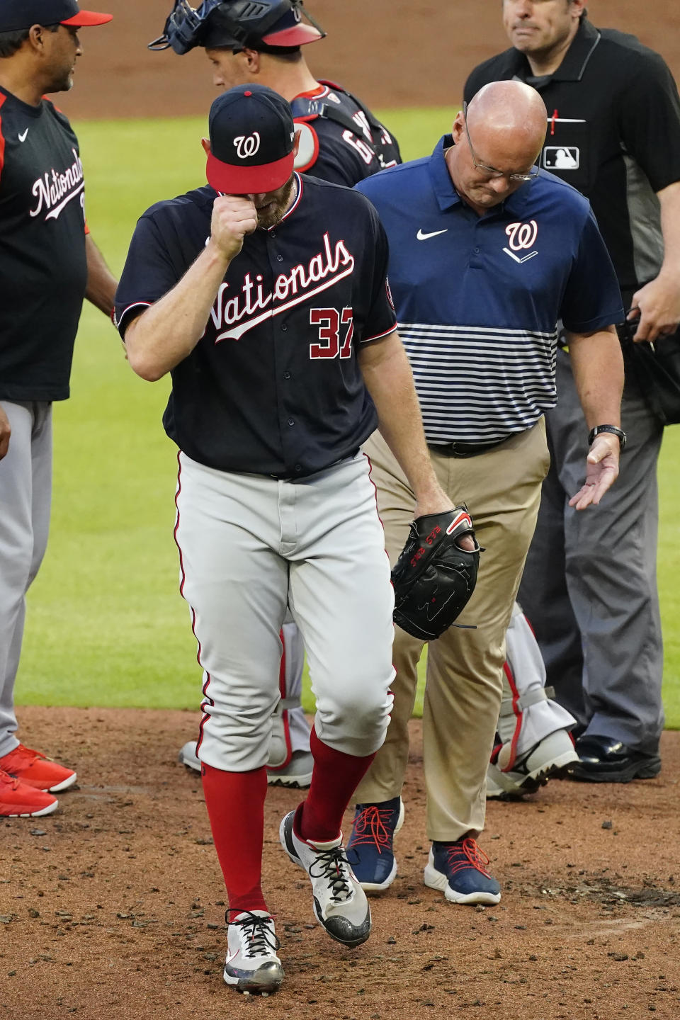 Washington Nationals starting pitcher Stephen Strasburg (37) leaves the field with a member of the team's medical staff in the second inning of a baseball game against the Atlanta Braves Tuesday, June 1, 2021, in Atlanta. (AP Photo/John Bazemore)