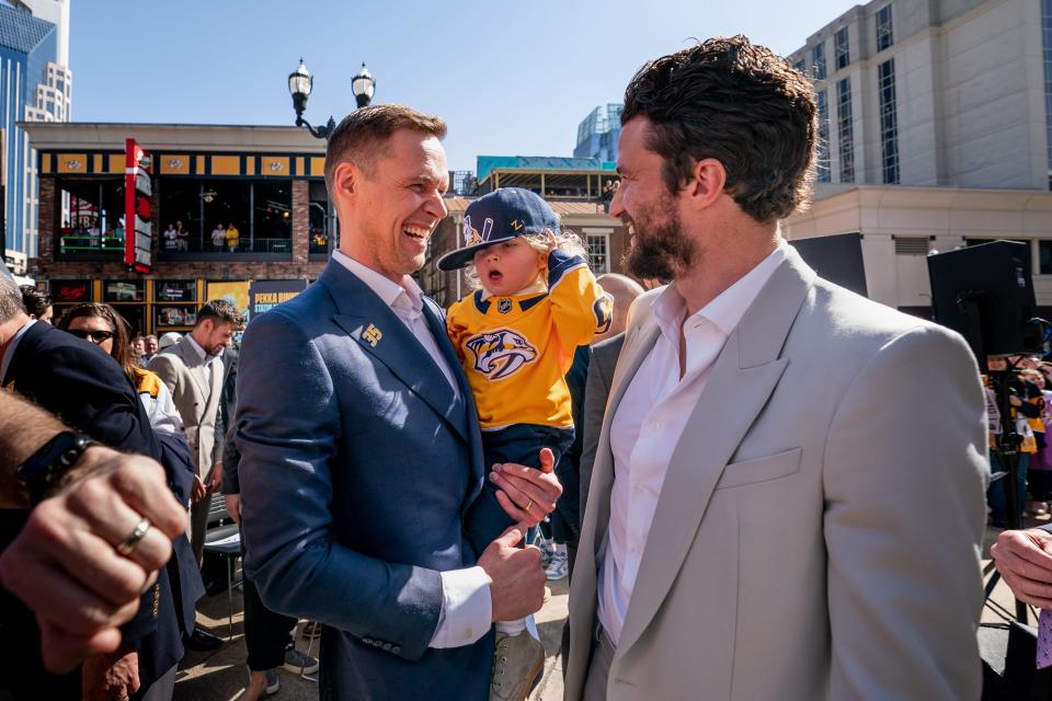 Former Nashville Predators goaltender Pekka Rinne, left, greets Predators defenseman Roman Josi, right, during the unveiling of Rinne’s statue at Bridgestone Arena in Nashville, Tenn., Saturday, March 25, 2023.