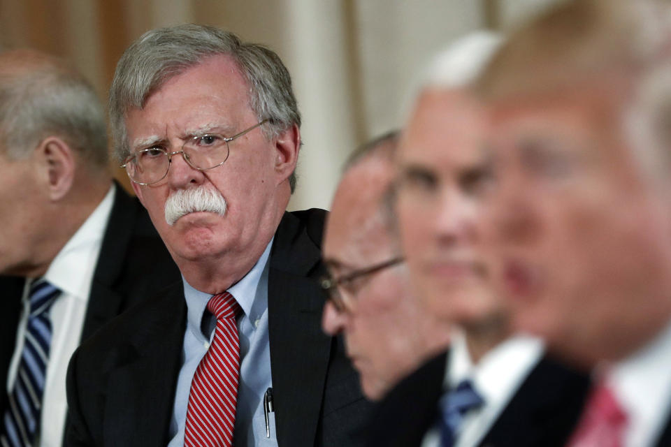 FILE - In this April 18, 2018 file photo, National security adviser John Bolton, left, listens to President Donald Trump, far right, speak during a working lunch with Japanese Prime Minister Shinzo Abe at Trump' s private Mar-a-Lago club in Palm Beach, Fla. Also at the meeting are from left, White House chief economic adviser Larry Kudlow, third left, and Vice President Mike Pence, second left. Trump has fired national security adviser John Bolton. Trump tweeted Tuesday that he told Bolton Monday night that his services were no longer needed at the White House. (AP Photo/Pablo Martinez Monsivais)