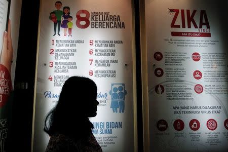 A woman stands near a poster explaining about the Zika virus at the Ministry of Health office in Jakarta, Indonesia September 2, 2016. REUTERS/Iqro Rinaldi/File Photo