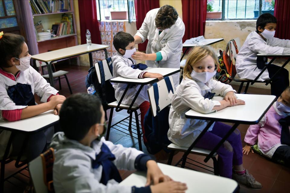 In this picture released by Adhoc news agency students of a rural school wear face masks in Puntas de San Pedro, Colonia department, Uruguay on April 22, 2020. - Half of the elementary rural schools of Uruguay -some 500 out of 973- were reopened Wednesday over a month after classes were suspended, in an attempt of having a "new normality" to coexist with the new coronavirus. (Photo by Daniel Rodriguez / adhoc / AFP) / Uruguay OUT / RESTRICTED TO EDITORIAL USE - MANDATORY CREDIT "AFP PHOTO / ADHOC / Daniel RODRIGUEZ " - NO MARKETING NO ADVERTISING CAMPAIGNS - DISTRIBUTED AS A SERVICE TO CLIENTS (Photo by DANIEL RODRIGUEZ/adhoc/AFP via Getty Images)