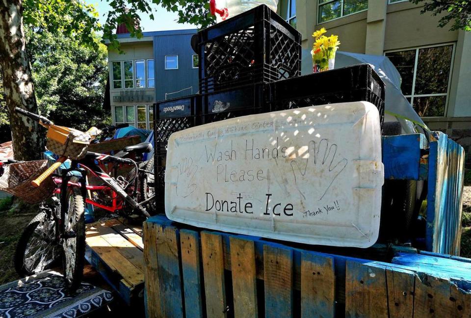 A sign outside Santario Pratt’s tent asks people to wash their hands and to donate ice.