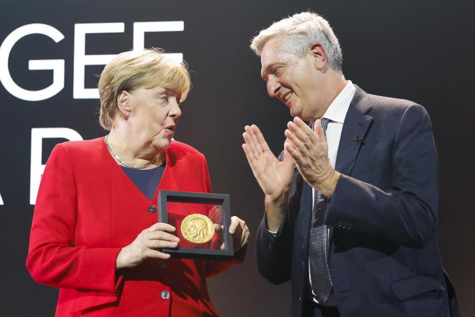 Angela Merkel receives the UNHCR Nansen Refugee Award for protecting refugees at the height of the Syria crisis, from United Nations High Commissioner for Refugees Filippo Grandi, during a ceremony in Geneva, Switzerland, Monday Oct. 10, 2022. (Stefan Wermuth/Pool via AP)