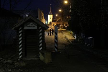 People stand in a street in Estonia near the border with Latvia in Valka, a town split between the two countries October 25, 2013. REUTERS/Ints Kalnins