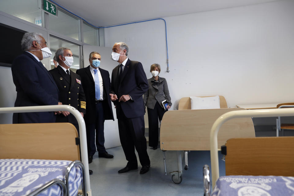 Portuguese President Marcelo Rebelo de Sousa, 2nd right, Prime Minister Antonio Costa, left, and Health Minister Marta Temido, right, visit a room in a new COVID-19 ward being set up at the Military Hospital in Lisbon, Tuesday, Jan. 26, 2021. The military hospital is expanding it's number of beds available to take COVID-19 patients from the National Health Service. Portugal is reporting new daily records of COVID-19 deaths and hospitalizations as a recent pandemic surge continues unabated. (AP Photo/Armando Franca)