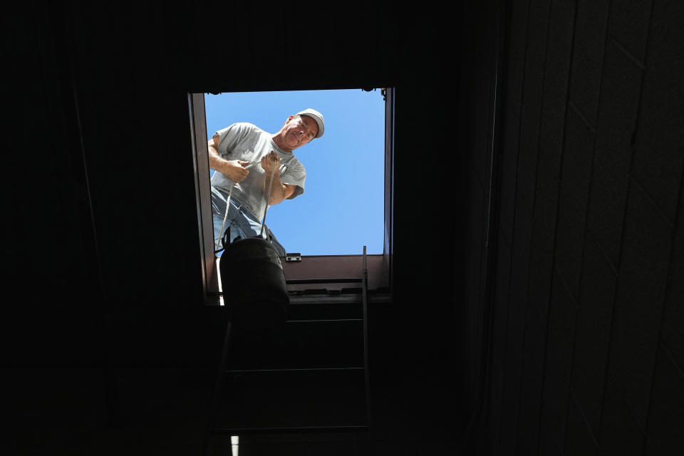 JP Lantin, owner of Total Refrigeration, works on a commerical air conditioning roof unit as temperatures are expected to hit 117-degrees, Wednesday, July 19, 2023, in Laveen, Ariz. (AP Photo/Ross D. Franklin)