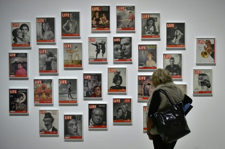 Une visiteuse regarde des Unes du magazine LIFE lors de l'exposition "Sorprendeme!", une rétrospective consacrée au photographe letton Philippe Halsman, le 30 novembre 2016 à Madrid (GERARD JULIEN)