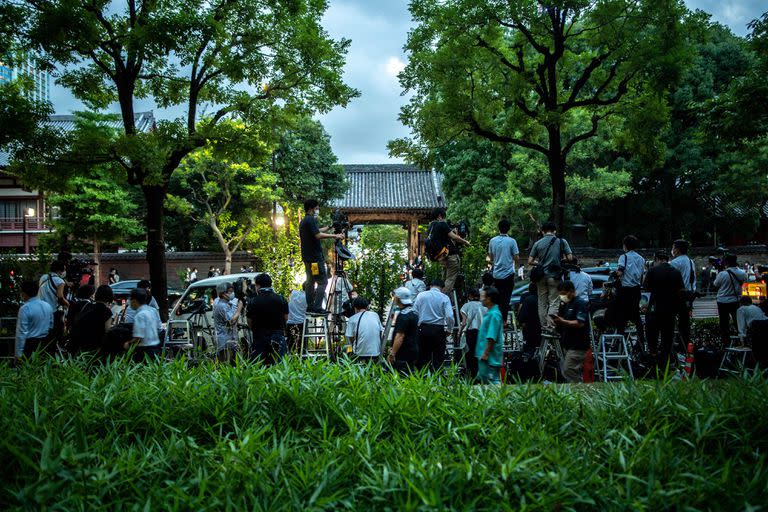 Miembros de los medios de comunicación se reúnen fuera del templo Zojoji mientras los dolientes llegan para asistir a un velatorio privado del fallecido ex primer ministro japonés Shinzo Abe en Tokio el 11 de julio de 2022.