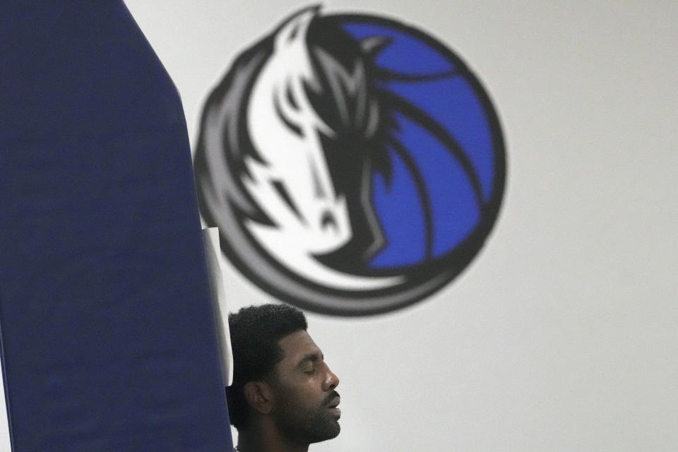 Dallas Mavericks guard Kyrie Irving closes his eyes as he leans on a basket post during an NBA basketball training camp in Dallas, Thursday, Sept. 28, 2023. (AP Photo/LM Otero)