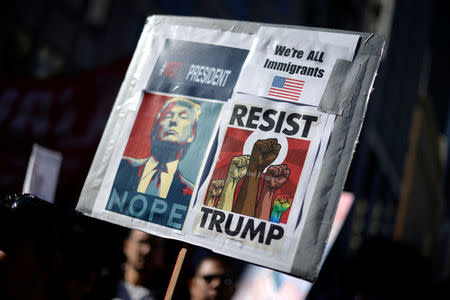 Protesters hold up signs during a march and rally against the United States President-elect Donald Trump in Los Angeles, California, U.S. December 18, 2016.REUTERS/Kevork Djansezian