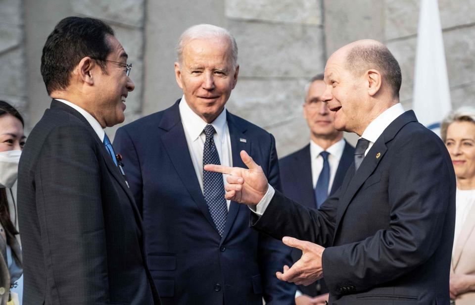 German Chancellor Olaf Scholz (R) greets Japan's Prime Minister Fumio Kishida (L) and US President Joe Biden (C) during a NATO summit at the alliance's headquarters in Brussels on March 24, 2022.