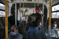 Commuters wearing masks ride a bus during the coronavirus pandemic in the Vermont Square neighborhood of Los Angeles, Thursday, May 21, 2020. While most of California took another step forward to partly reopen in time for Memorial Day weekend, Los Angeles County didn't join the party because the number of coronavirus cases has grown at a pace that leaves it unable to meet even the new, relaxed state standards for allowing additional businesses and recreational activities. (AP Photo/Jae C. Hong)