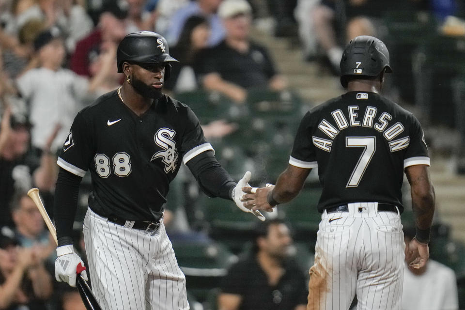 Chicago White Sox's Luis Robert Jr., left, slaps hands with teammate Tim Anderson after Anderson scored during the third inning of a baseball game against the Detroit Tigers, Friday, Sept. 1, 2023, in Chicago. (AP Photo/Erin Hooley)