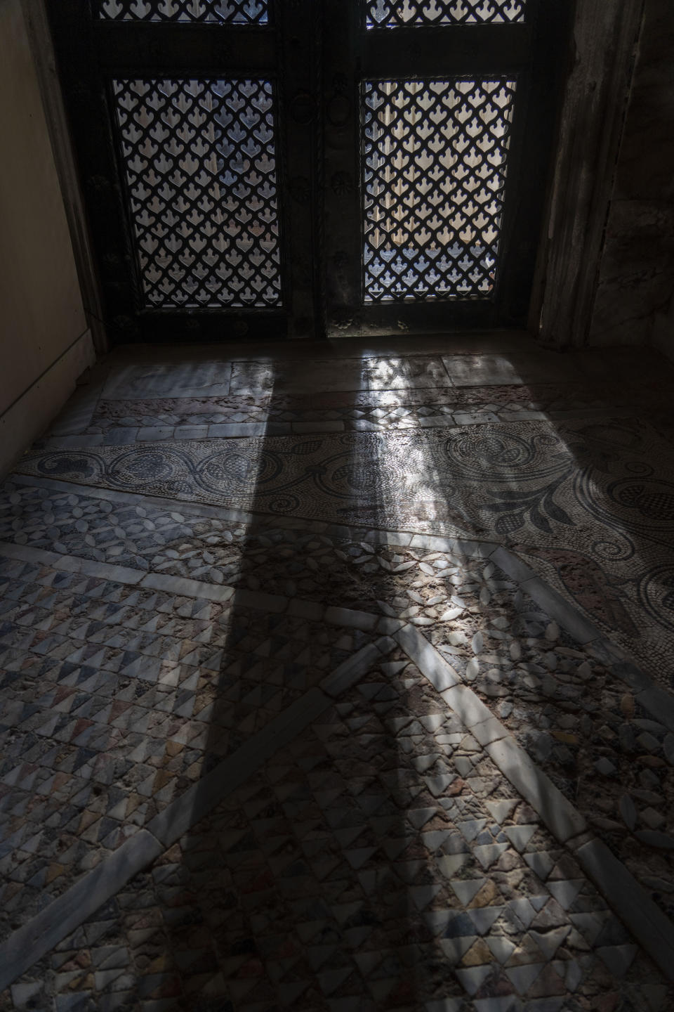 The sunlight filtering through one of the doors of St. Mark's Basilica casts patterns on the floor mosaics bleached by seawaters in Venice, northern Italy, Wednesday, Dec. 7, 2022. Glass barriers that prevent seawater from flooding the 900-year-old iconic Venice's Basilica have been recently installed around it. St. Mark's Square is the lowest-laying city area and frequently ends up underwater during extreme weather. (AP Photo/Domenico Stinellis)