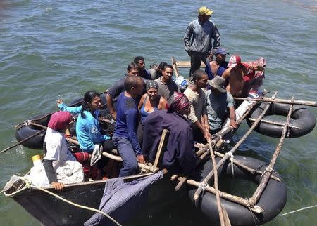 A home-made aluminium boat carrying 16 Cuban migrants pulls up to a dock, seeking what the migrants said was refuge from rough seas, in Grand Cayman island August 28, 2014.REUTERS/Peter Polack