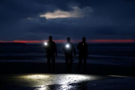 French gendarmes patrol the beach just after sunset in Wissant, France, January 11, 2019. Picture taken January 11, 2019. REUTERS/Pascal Rossignol