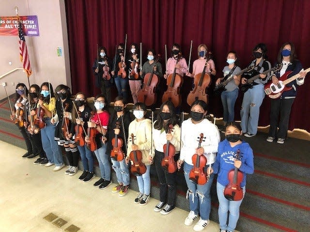 Members of the James Workman Middle School String Orchestra line up for a group photo.