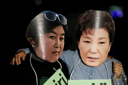 Protesters wearing cut-out of South Korean President Park Geun-hye (R) and Choi Soon-sil attend a protest denouncing President Park Geun-hye over a recent influence-peddling scandal in central Seoul, South Korea, October 27, 2016. REUTERS/Kim Hong-Ji