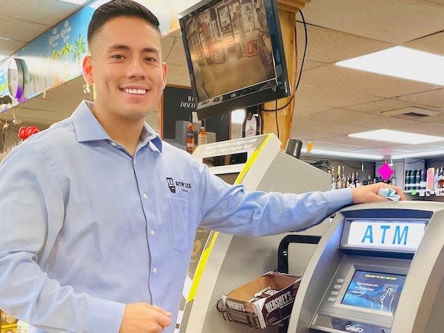 Paul Alex standing next to one of his ATM machines.