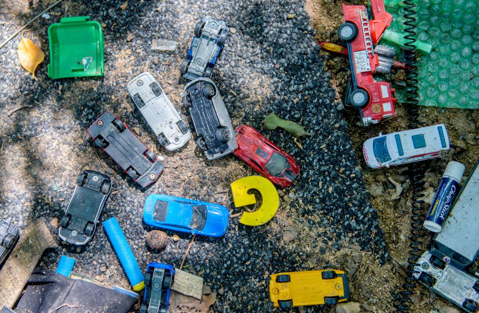 Tiny cars and other toys lie amongst debris surrounding a homeless encampment near the Landmark Recreation Center in Peoria.