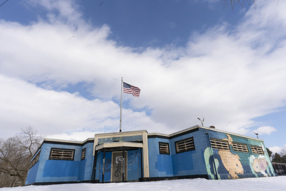 The U.S. flag flies over the Pulaski Park pool house in Poughkeepsie, N.Y., Tuesday, Jan. 25, 2022. Poughkeepsie was rated by the New York comptroller as the state’s most financially stressed community in 2020. The more than $20 million it is getting from the American Rescue Plan cannot be used to wipe out the deficit, but the city plans to make major improvements to parks and swimming pools, including a complete rebuild of a run-down bathhouse that has been relying on portable toilets. (AP Photo/Mary Altaffer)