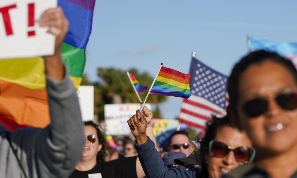 <span>Marchers wave US and rainbow flags and signs as they march in St Petersburg, Florida, in March 2022 to protest the controversial ‘don't say gay’ bill.</span><span>Photograph: Martha Asencio-Rhine/AP</span>