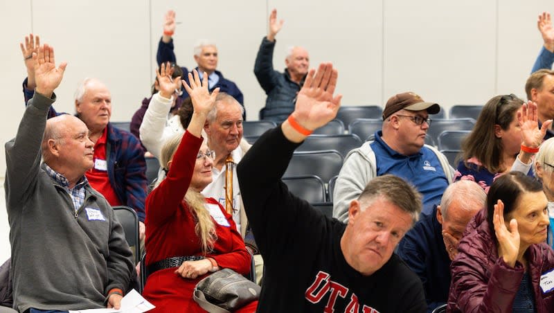 Attendees raise their hands at a Republican caucus at Rock Canyon Elementary School in Provo on Tuesday, March 5, 2024.