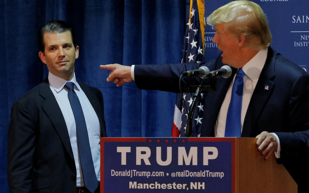 Then Republican presidential candidate Donald Trump welcomes his son Don Jr. to the stage at a November 2015 event in Manchester, New Hampshire - REUTERS