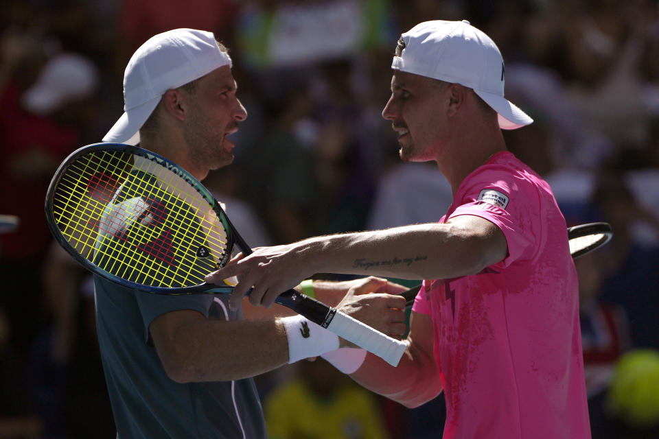 Grigor Dimitrov, left, of Bulgaria is congratulated by Marton Fucsovics of Hungary following their first round match at the Australian Open tennis championships at Melbourne Park, Melbourne, Australia, Tuesday, Jan. 16, 2024. (AP Photo/Louise Delmotte)