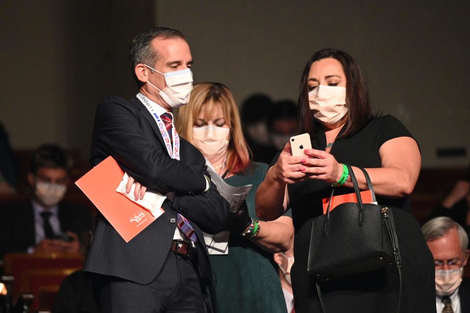 Los Angeles Mayor Eric Garcetti, left, wears a facemask as he arrives for the 2020 vice presidential debate.