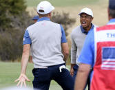 U.S. team player Justin Thomas, left, celebrates with his playing partner and captain, Tiger Woods, on the 18th green in their foursomes match during the President's Cup golf tournament at Royal Melbourne Golf Club in Melbourne, Friday, Dec. 13, 2019. (AP Photo/Andy Brownbill)