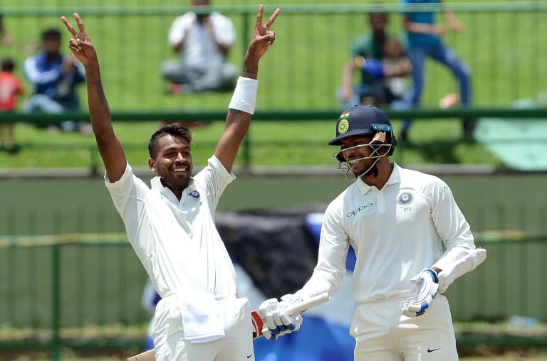 India's Hardik Pandya (L) celebrates with his teammate Umesh Yadav after scoring a century on the second day of their third Test against Sri Lanka at the Pallekele International Cricket Stadium in Pallekele on August 13, 2017