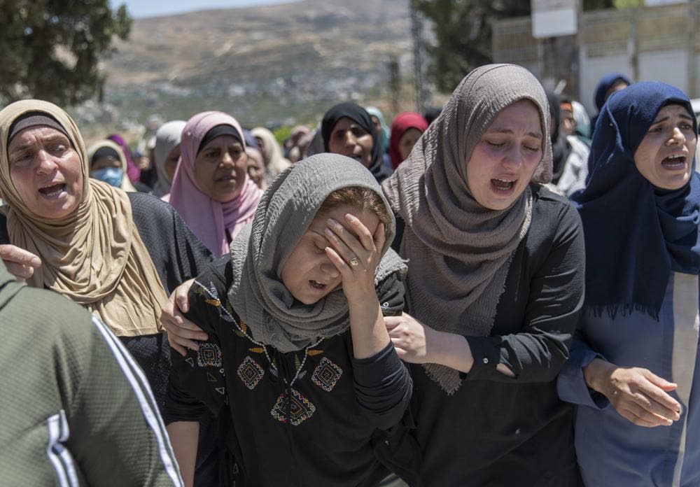 Palestinian mourners cry during the funeral of Husam Asayra, 20 in the West Bank village of Asira al-Qibliya, near Nablus, Saturday, May 15, 2021. (AP Photo/Nasser Nasser)