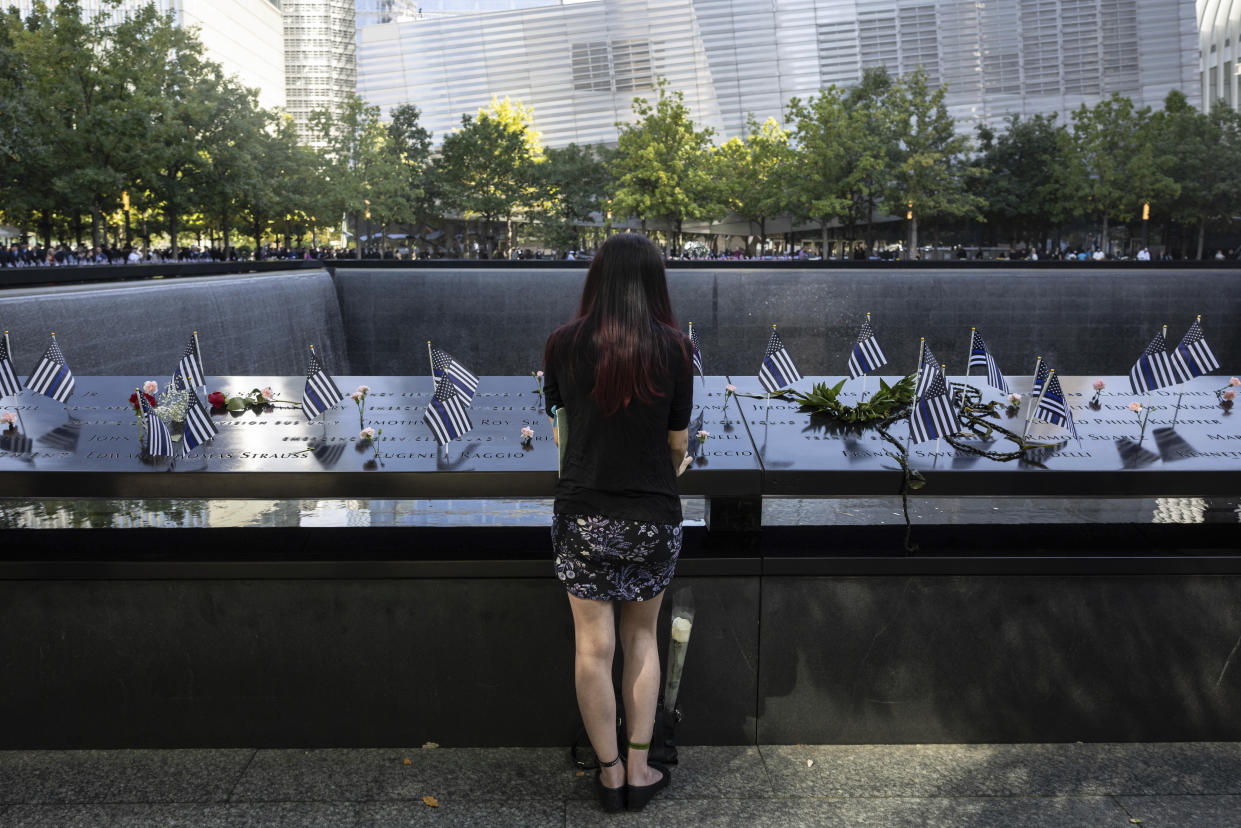 Mercedes Arias stands by the name of her father Joseph Amatuccio along the south reflection pool during the 9/11 Memorial ceremony in New York City on Wednesday. 