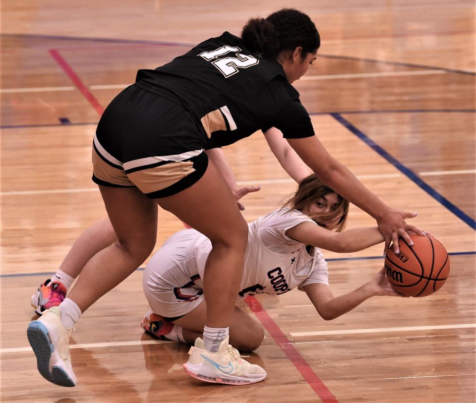 Cooper's Mya Chavez looks pass the ball after coming up with a loose ball as Lubbock High's Faith Ford defends.