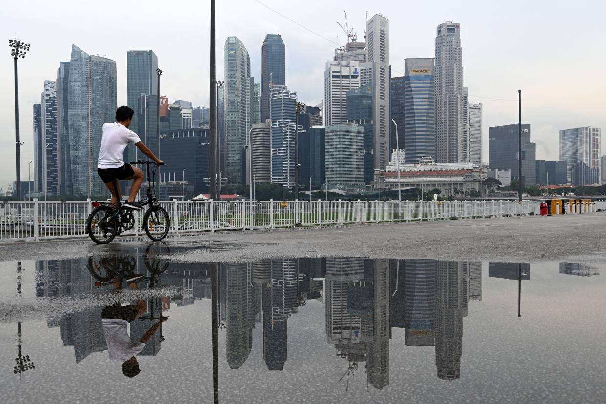 A cyclist rides before the city skyline at Marina bay in Singapore. (Photo by ROSLAN RAHMAN / AFP) (PHOTO: Rosland Rahman/AFP via Getty Images)