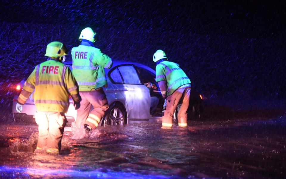 Firemen help a occupant of a car on a flooded road in Penarth, South Wales. - Ben Evans/Huw Evans Agency /Huw Evans Picture Agency 