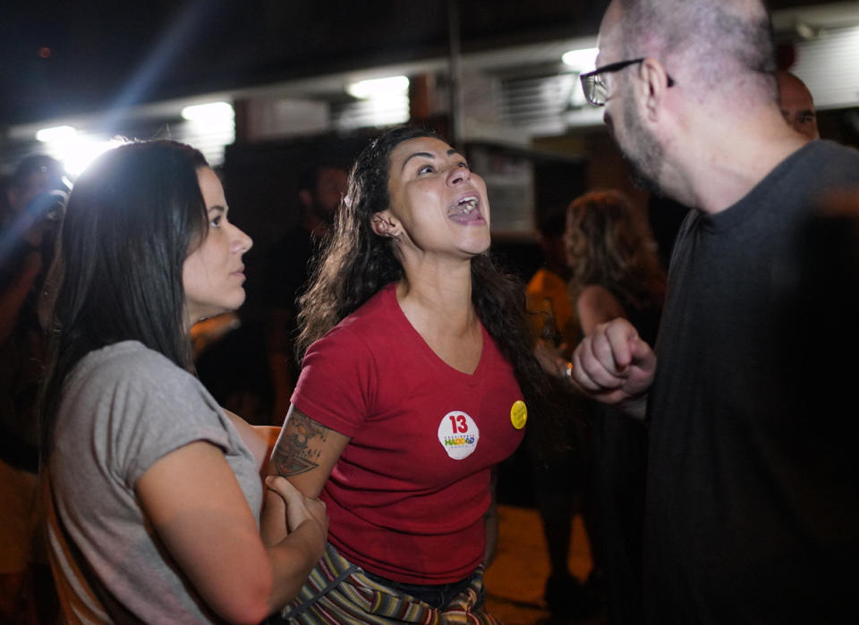 A supporter of Workers' Party presidential candidate Fernando Haddad, center, verbally attacks a supporter of presidential candidate Jair Bolsonaro, after Bolsonaro was declared the winner of the election runoff, in Rio de Janeiro, Brazil, Sunday, Oct. 28, 2018. Brazil’s Supreme Electoral Tribunal declared the far-right congressman the next president of Latin America’s biggest country, with 96 percent of ballots counted. (AP Photo/Ricardo Borges)