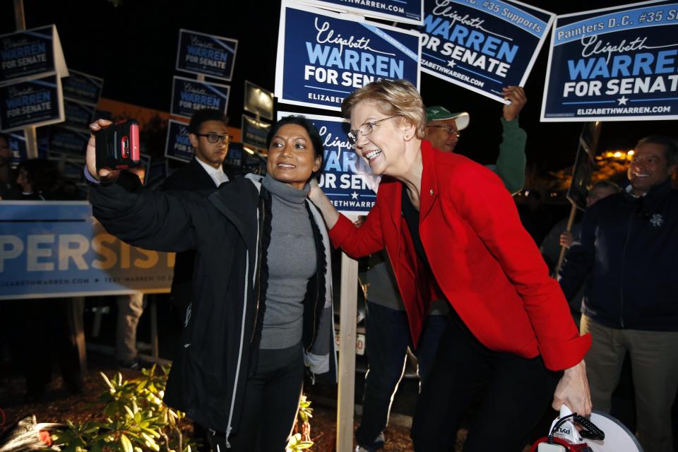 Sen. Elizabeth Warren poses for a selfie while greeting supporters before a debate with her Republican opponent Geoff Diehl in Boston, Friday, Oct. 19, 2018. (AP Photo/Michael Dwyer)