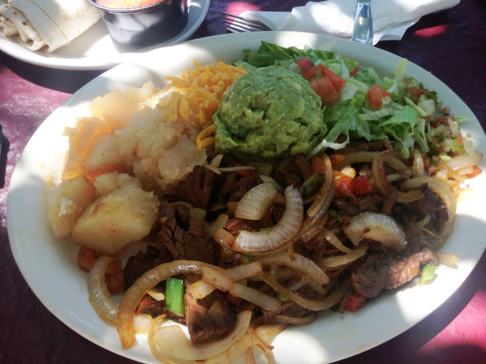 In this Sept 5, 2013 photo, a fajita plate from El Patio de Albuquerque is shown. El Patio is a longtime, unpretentious eatery near Albuquerque’s University of New Mexico campus, and is one of the city’s most popular dining spots. For nearly four decades, multi-generational families, tourists, professors, students _ even celebrities _ have lined up outside this former house for robust but simple fare like carne adovada and green chile enchiladas. (AP Photo/Russell Contreras)