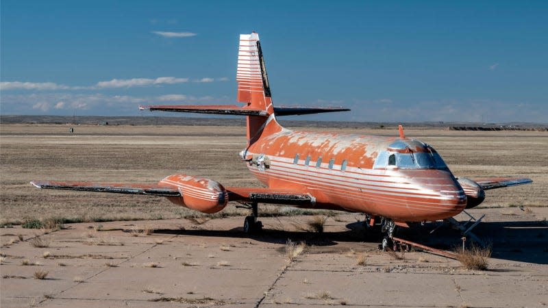 A photo of a red and silver plane on a runway. 