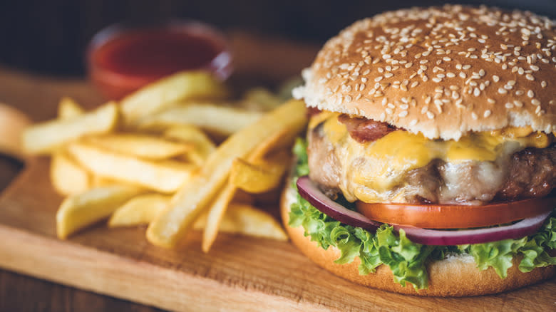 Hamburger and fries on cutting board