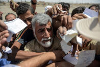 <p>Iraqis queue to receive food rations in an area outside Mosul’s Old City on June 22, 2017, during the ongoing offensive by Iraqi forces to retake the last district still held by the Islamic State (IS) group. (Photo: Mohamed el-Shahed/AFP/Getty Images) </p>