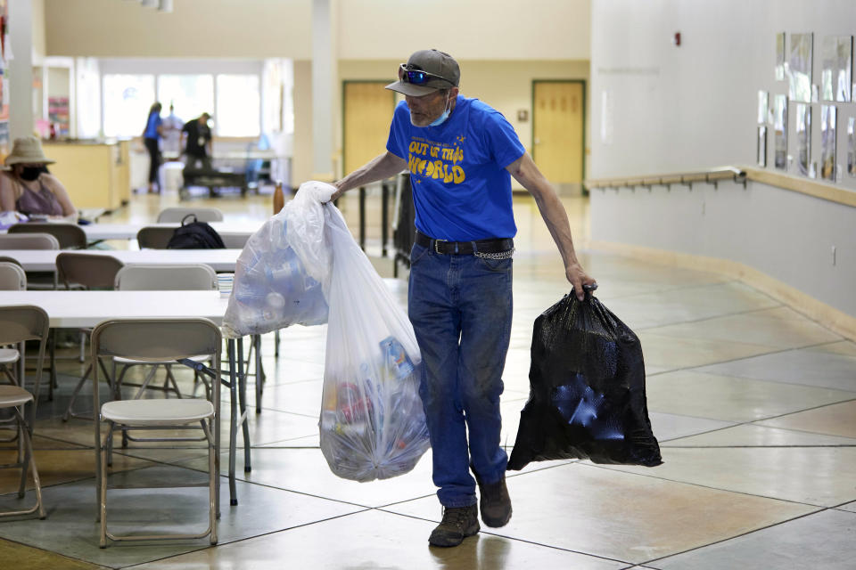 Rory Lidster, 55, brings in his belongings after checking into a cooling center in Portland, Ore., Tuesday, July 26, 2022. Temperatures are expected to top 100 degrees F (37.8 C) on Tuesday and wide swaths of western Oregon and Washington are predicted to be well above historic averages throughout the week. "I think these cooling shelters are a real good thing, that the elderly really need them and that all people really need them in this kind of heat," Lidster said. (AP Photo/Craig Mitchelldyer)