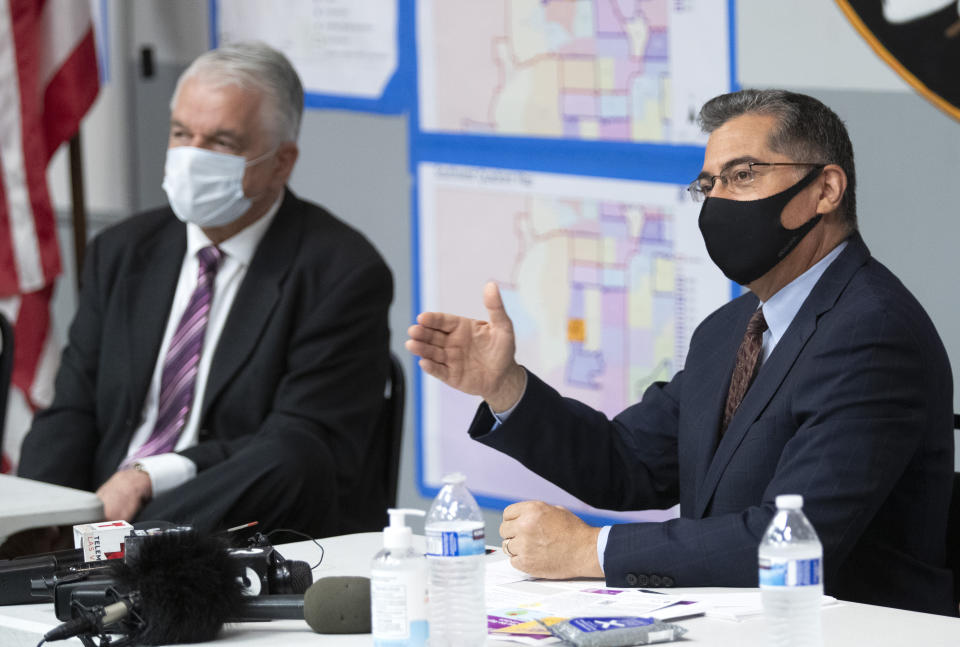 U.S. Department of Health and Human Services (HHS) Secretary Xavier Becerra, right, responds to a question following a briefing from officials at the Clark County Fire Department Training Facility in Las Vegas Thursday, July 22, 2021. Nevada Governor Steve Sisolak listens at left. (Steve Marcus /Las Vegas Sun via AP)