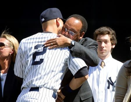 Sep 7, 2014; New York, NY, USA; New York Yankees shoftstop Derek Jeter gets a hug from his father Sanderson Charles while being honored at a ceremony before the game against the Kansas City Royals at Yankee Stadium. William Perlman/THE STAR-LEDGER via USA TODAY Sports