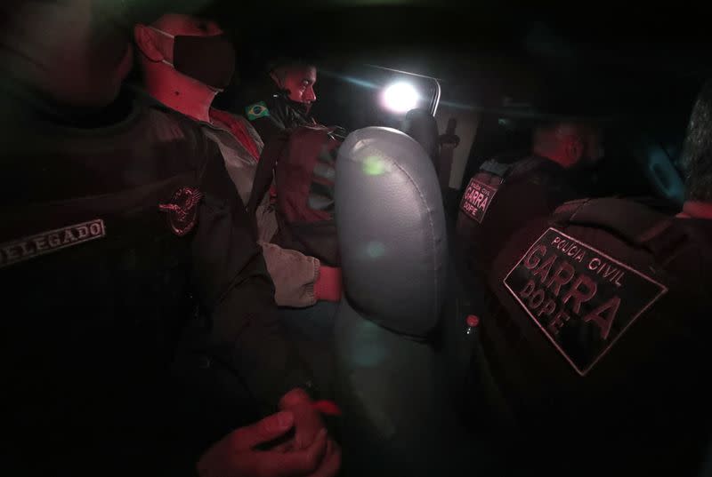 Queiroz, former advisor and former driver of Senator Flavio Bolsonaro, is seen between police officers as he leaves the Homicide and Personnel Protection Department of the Civil Police in Sao Paulo