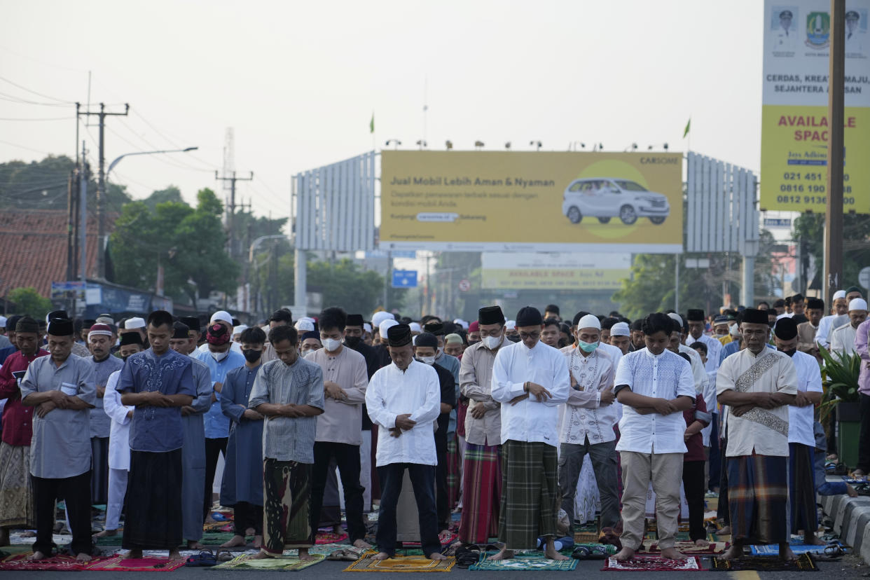 Muslims perform Eid al-Fitr prayer marking the end of the holy fasting month of Ramadan on a street in Bekasi, West Java, Indonesia, Monday, May 2, 2022. (AP Photo/Achmad Ibrahim)