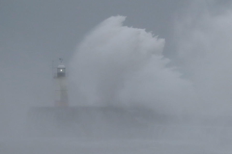 Waves crash over the harbour wall by a lighthouse as Storm Ciara hits Newhaven, on the south coast of England, Sunday, Feb. 9, 2020. Trains, flights and ferries have been cancelled and weather warnings issued across the United Kingdom and in northern Europe as the storm with winds expected to reach hurricane levels batters the region. (AP Photo/Matt Dunham)