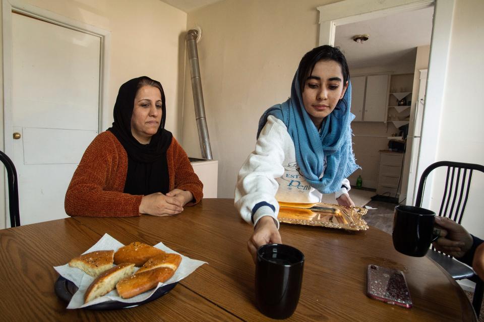 Afghan refugees Haieda Sharifi, right, serves black tea as her mother Fawzia Nijrabi looks on, on March 16, 2022, in the dining room of their new home in Erie. 